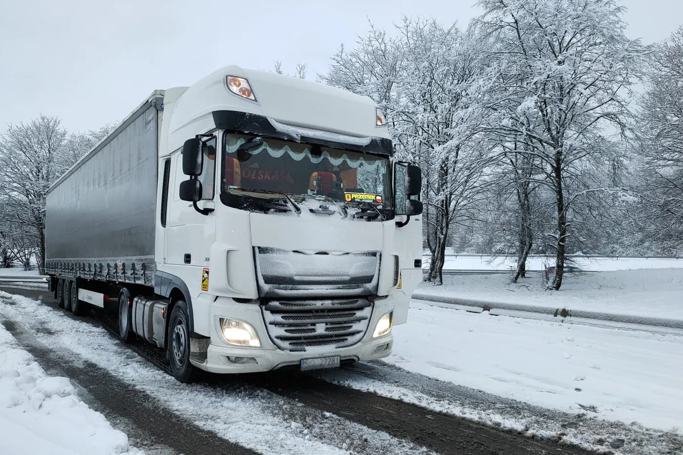 Zestaw DAF z naczepą na zaśnieżonej drodze zimą